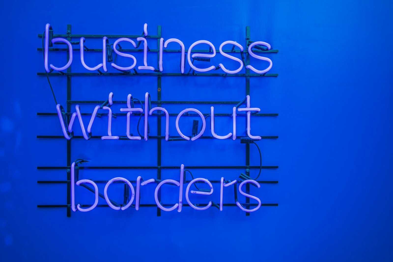 Blue neon sign reading business without borders