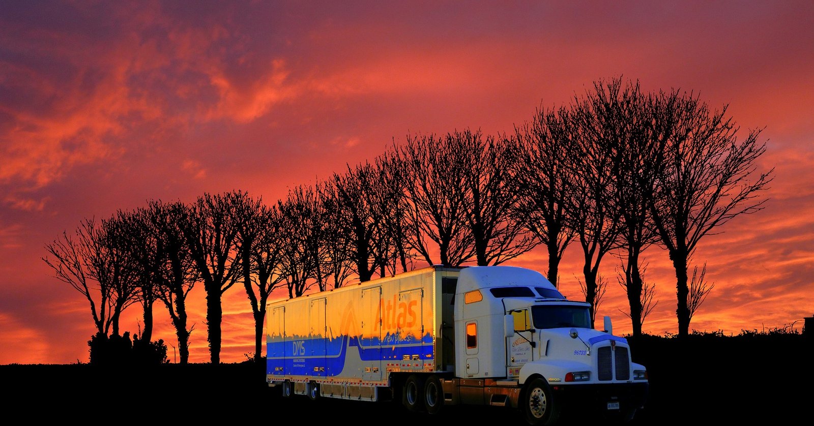 Freight truck travelling on a road at sunset