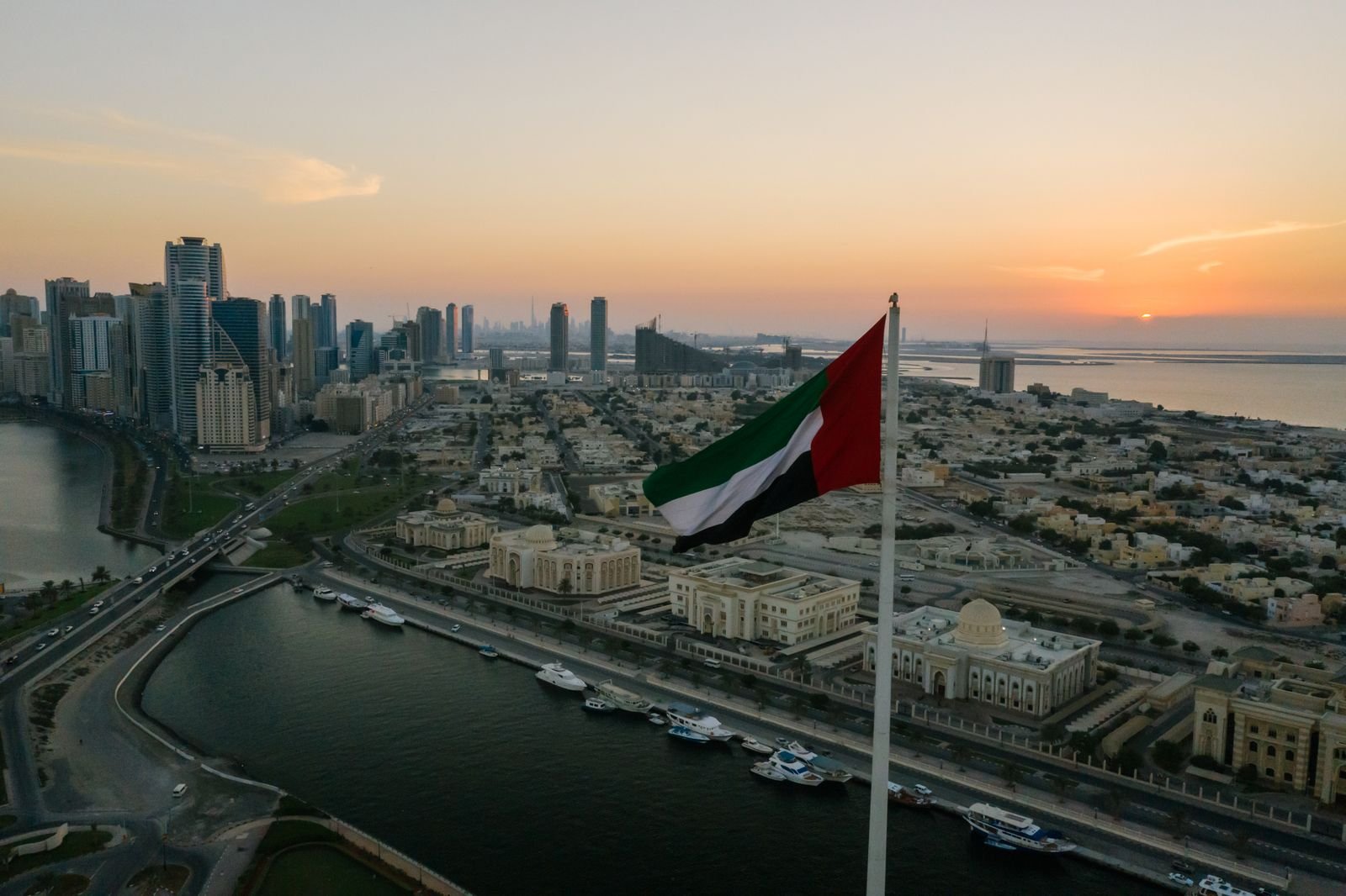 Dubai skyline and UAE flag at sunset